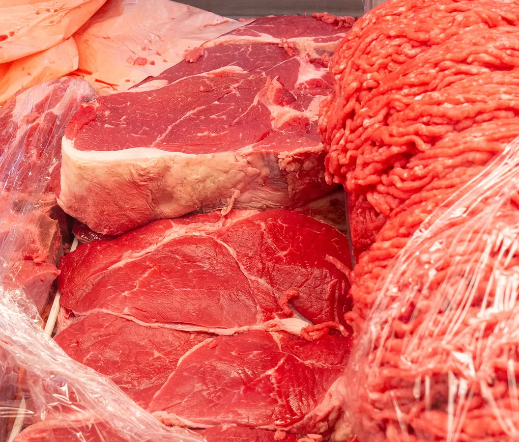 Fresh beef cuts and ground meat displayed in the butcher section at Juniors Market