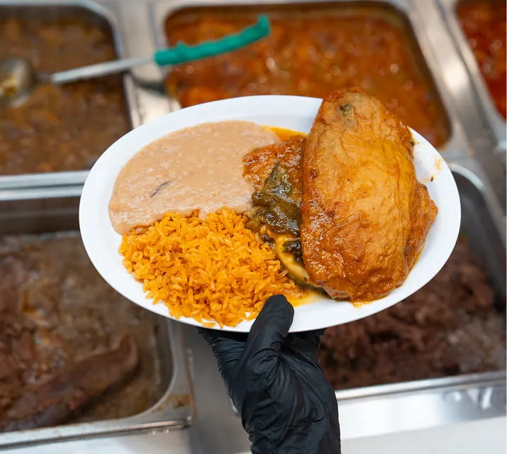 Fresh hot food plate with rice, beans, and chicken served at Juniors Market deli counter