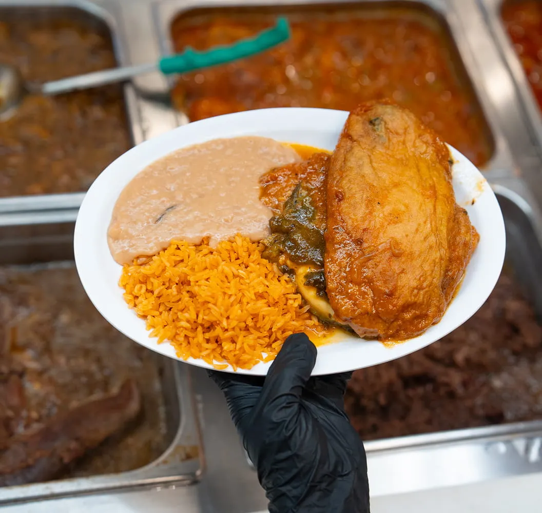 Fresh hot meal with rice, beans, and chicken served at Juniors Market deli and kitchen counter